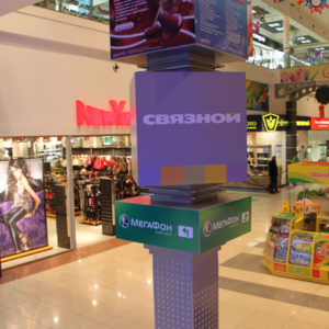 Многометровая рекламная конструкция в холле интерьера торгового центра